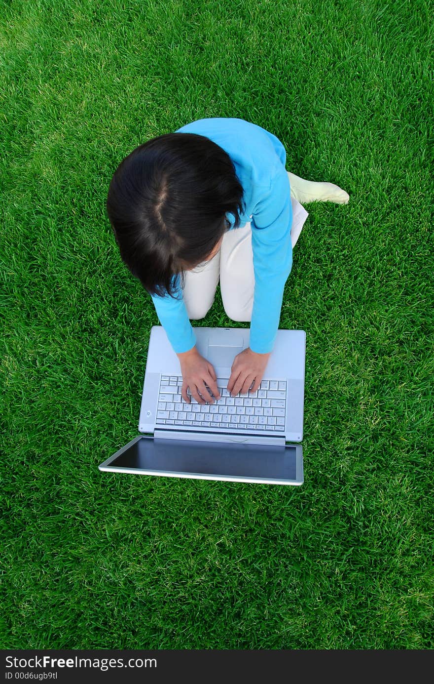 A girl with computer on the grass. A girl with computer on the grass