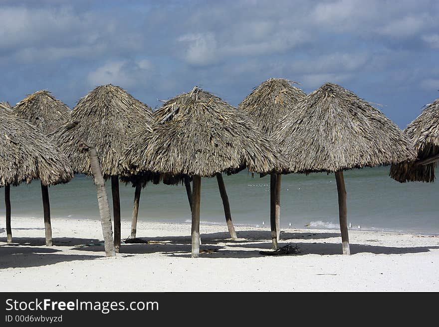 A group of sun shelters on the beach waiting for tourists. A group of sun shelters on the beach waiting for tourists.