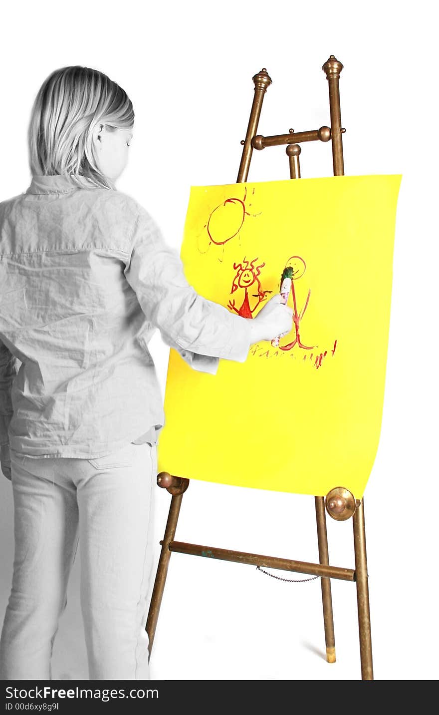 Young girl painting on a easel, yellow paper. Young girl painting on a easel, yellow paper.