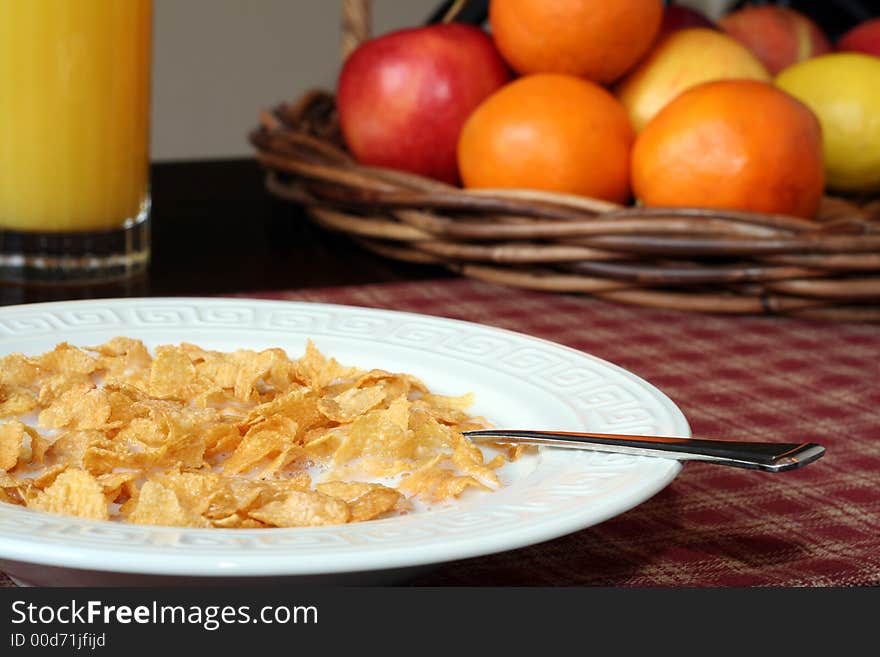 Cereal and milk, with fruit and juice in the background. Cereal and milk, with fruit and juice in the background.