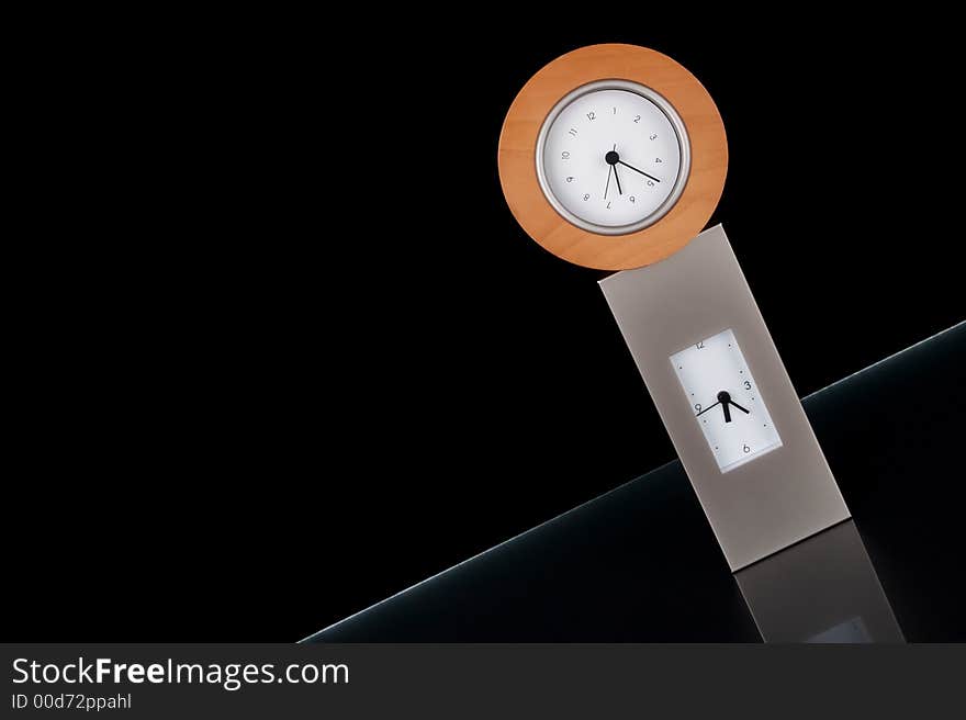 Two clocks stacked on each other against a black background.