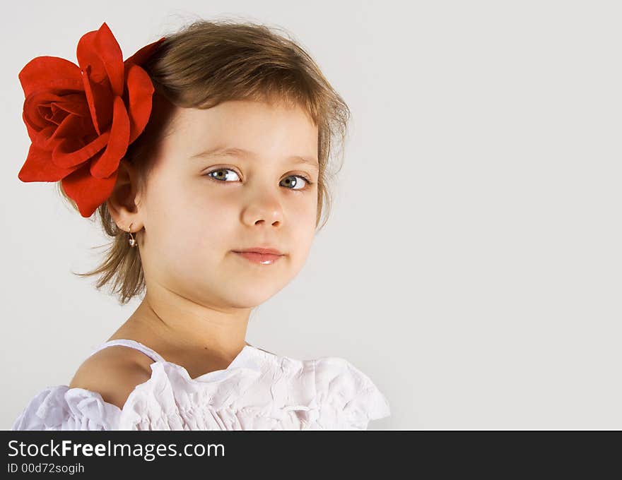 Little girl with red rouses in the hair