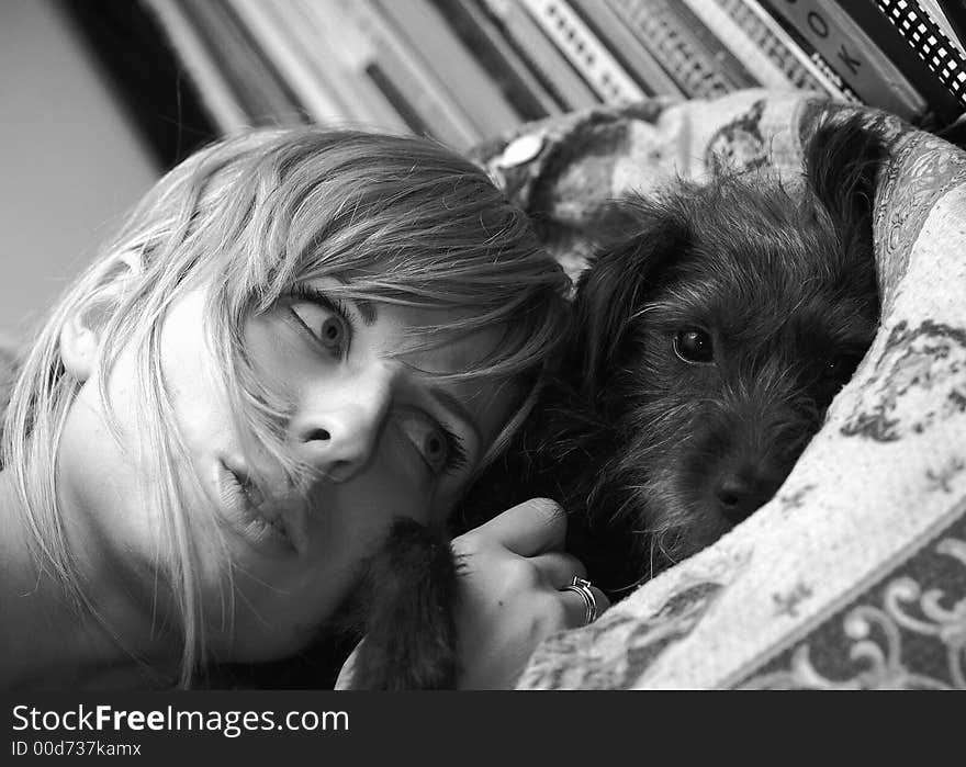 Girl and dog are lying on bed. Black-white photo. Girl and dog are lying on bed. Black-white photo.