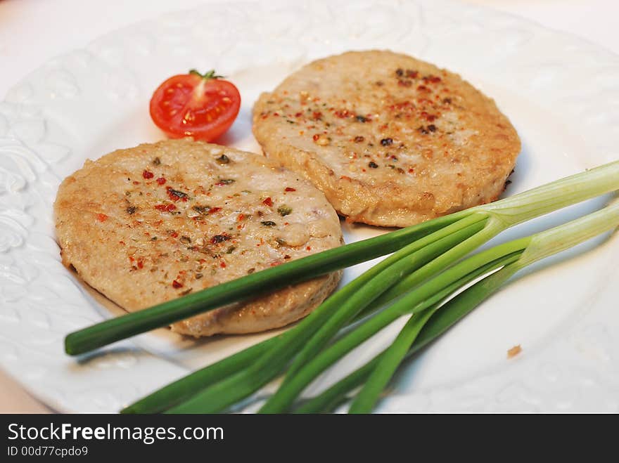 Two hamburgers with onion and tomato