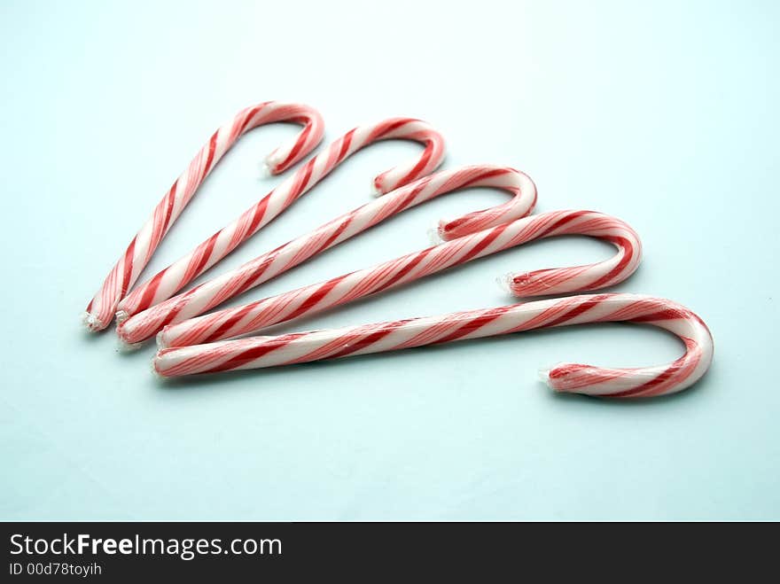 Five candy canes on a white background