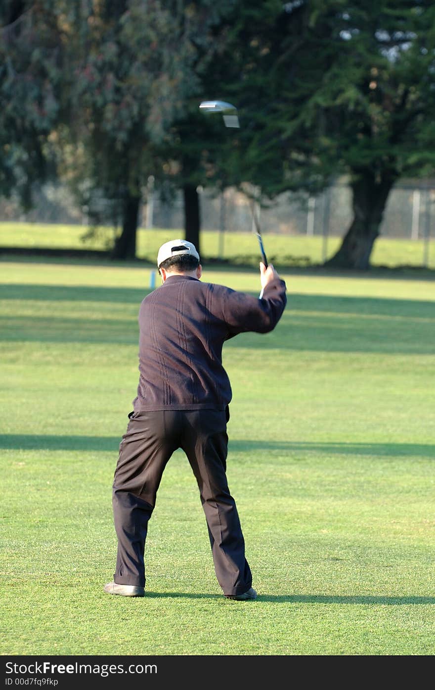 Golfer in mid swing with head of club in motion. Golfer in mid swing with head of club in motion