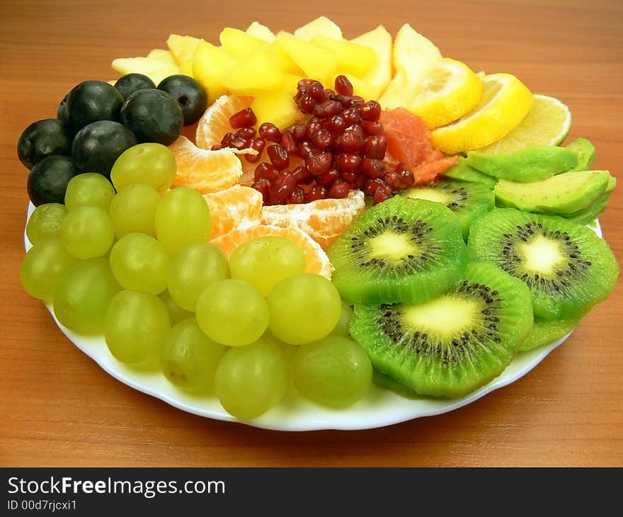 Grapes, orange, pomegranate, grapefruit, mango, avocado, apple, kiwi and slices of lemon. Grapes, orange, pomegranate, grapefruit, mango, avocado, apple, kiwi and slices of lemon