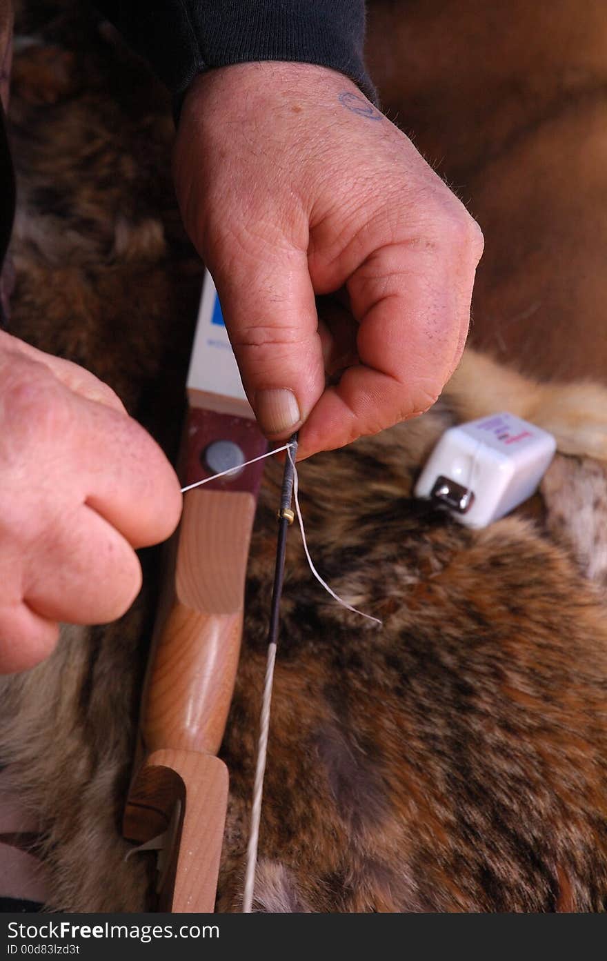 Archer repairing bow string