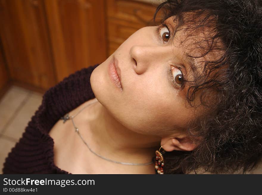 Woman with black hair look upward in camera. Woman with black hair look upward in camera