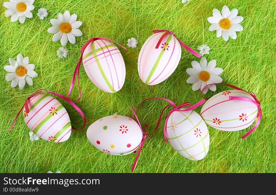 Closeup of several Easter eggs over green grass.