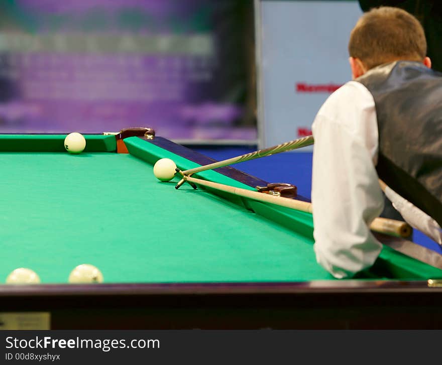 The player in billiards shooting on a ball