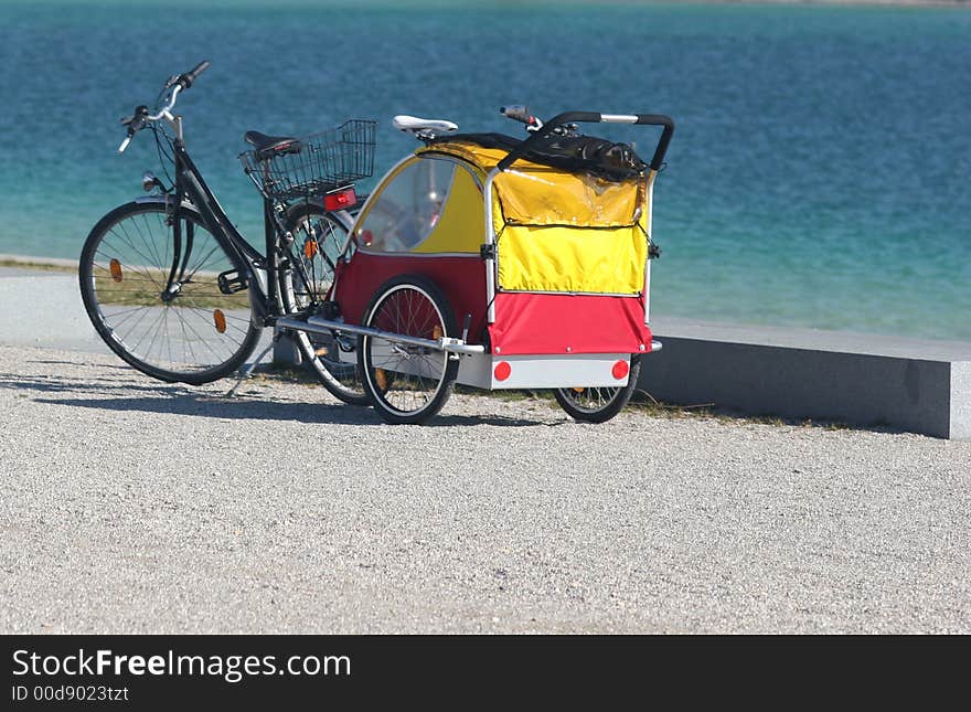 Bike and children cab on the blue water background. Bike and children cab on the blue water background