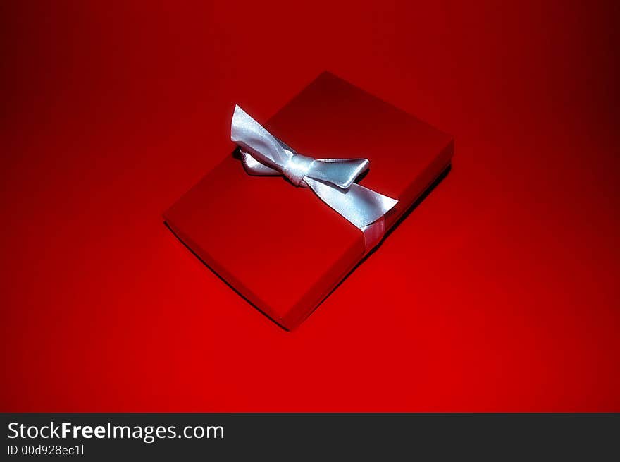 A red gift box with a silver ribbon. A red gift box with a silver ribbon.