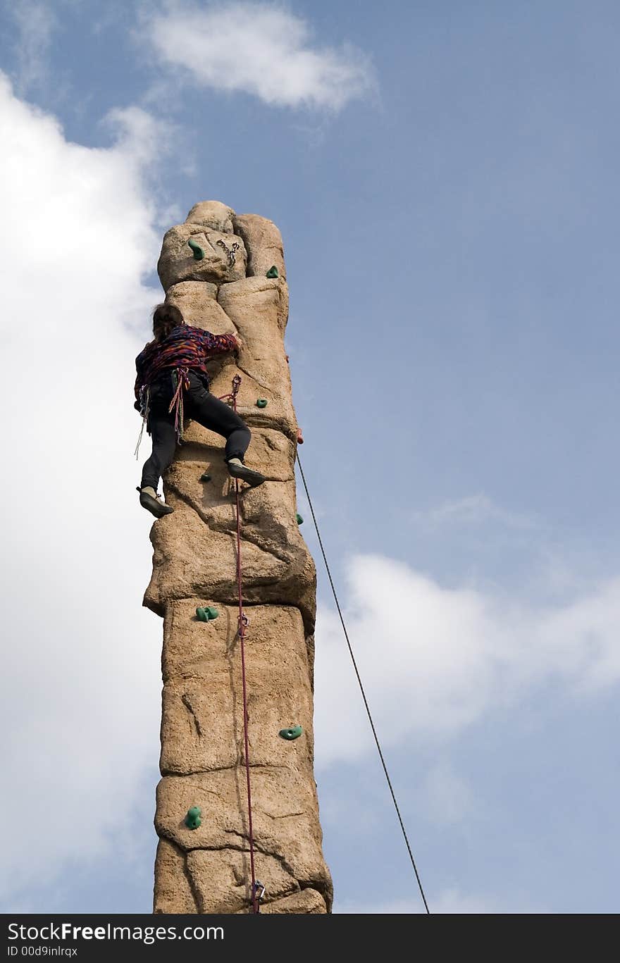 A young man climb a climbing wall. He is secured by rope, which leads by certain safeguarding points, against a crash. The climbing wall is located in Berlin in the scene quarter “Prenzlauer Berg” in Germany. A young man climb a climbing wall. He is secured by rope, which leads by certain safeguarding points, against a crash. The climbing wall is located in Berlin in the scene quarter “Prenzlauer Berg” in Germany.