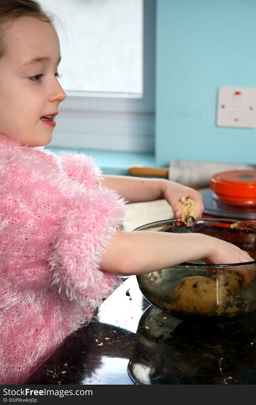 Young girl mixing food ingredients in a bowl with her hands. Young girl mixing food ingredients in a bowl with her hands