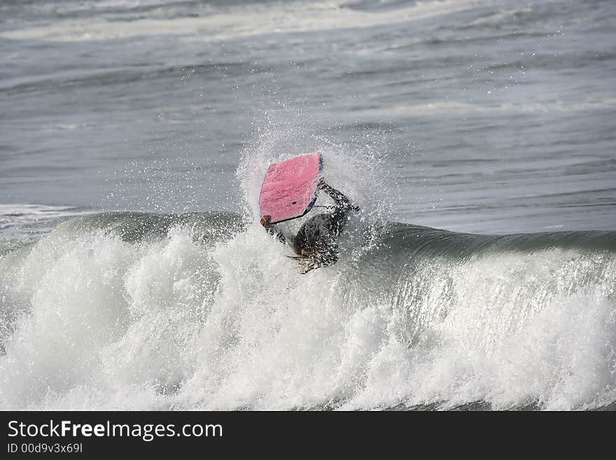 Photo of a bodyboarder on top of the wave