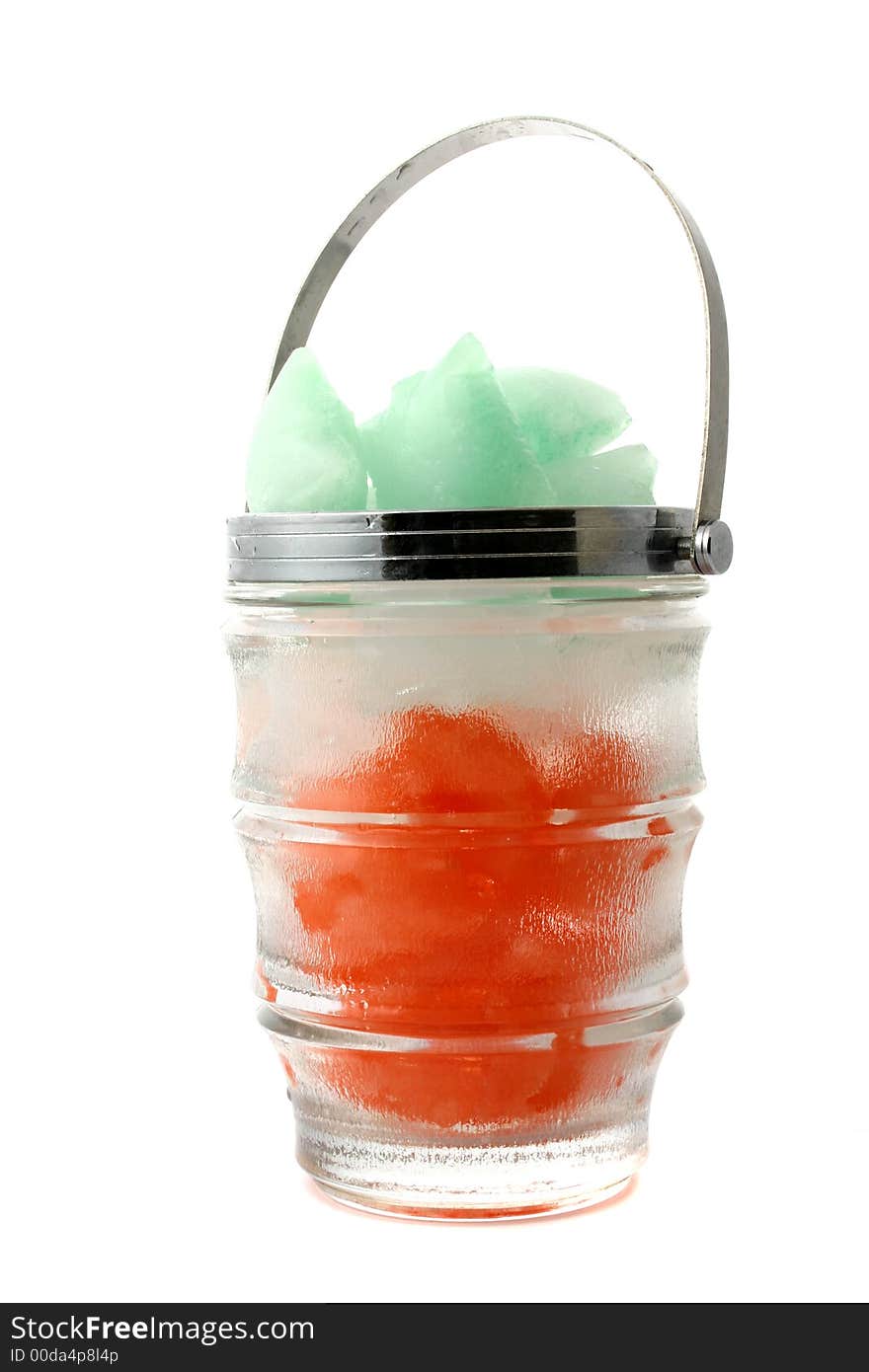 Green, red and white ice cubes put in a glass jug with metal handle. Green, red and white ice cubes put in a glass jug with metal handle