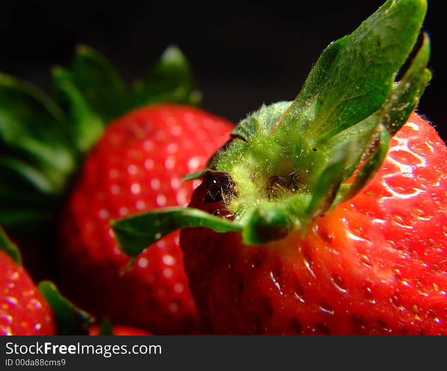 A close up of a strawberry, with green leaves too. A close up of a strawberry, with green leaves too.