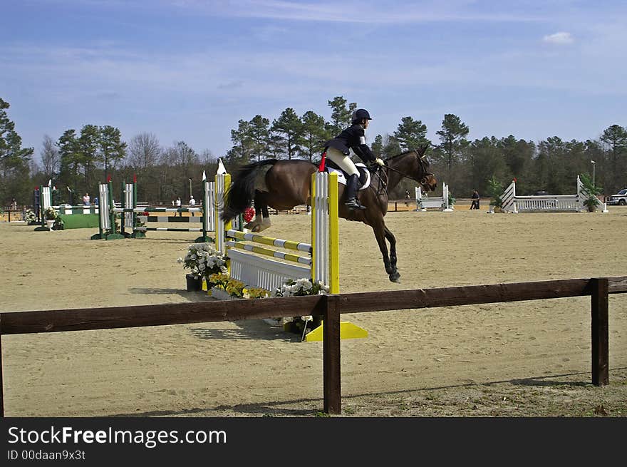 Horse and rider clearing a hurdle at a horse show. Horse and rider clearing a hurdle at a horse show