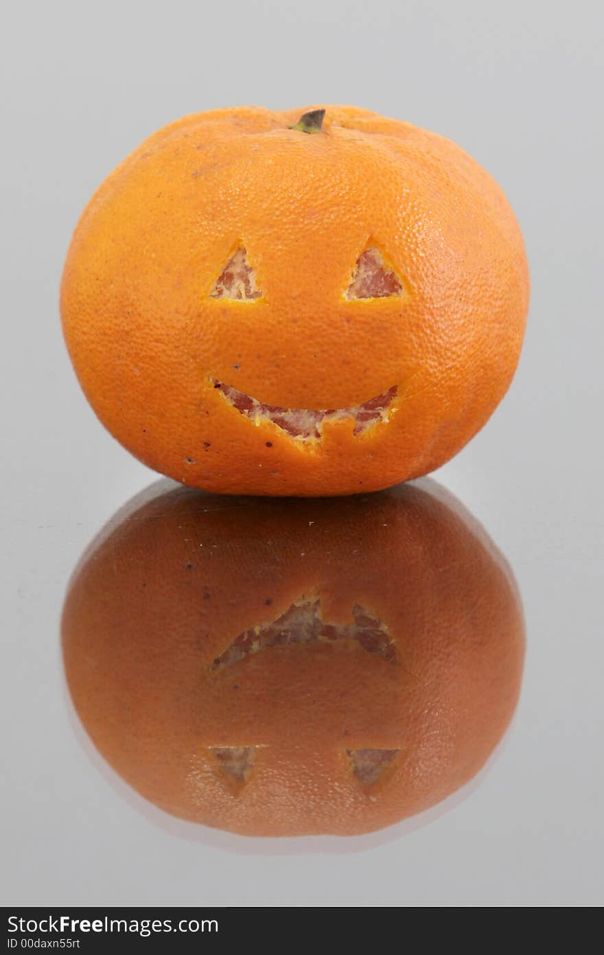 Orange mandarin with Halloween type cut out for fun. Orange mandarin with Halloween type cut out for fun