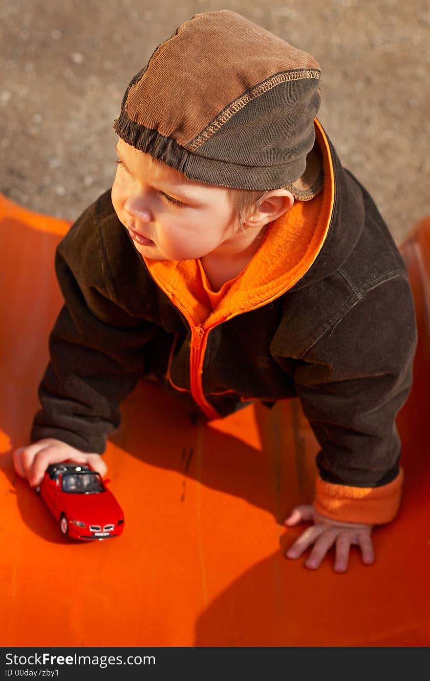 Lovely Baby Boy with beautiful blue eyes playing with toy car in the park