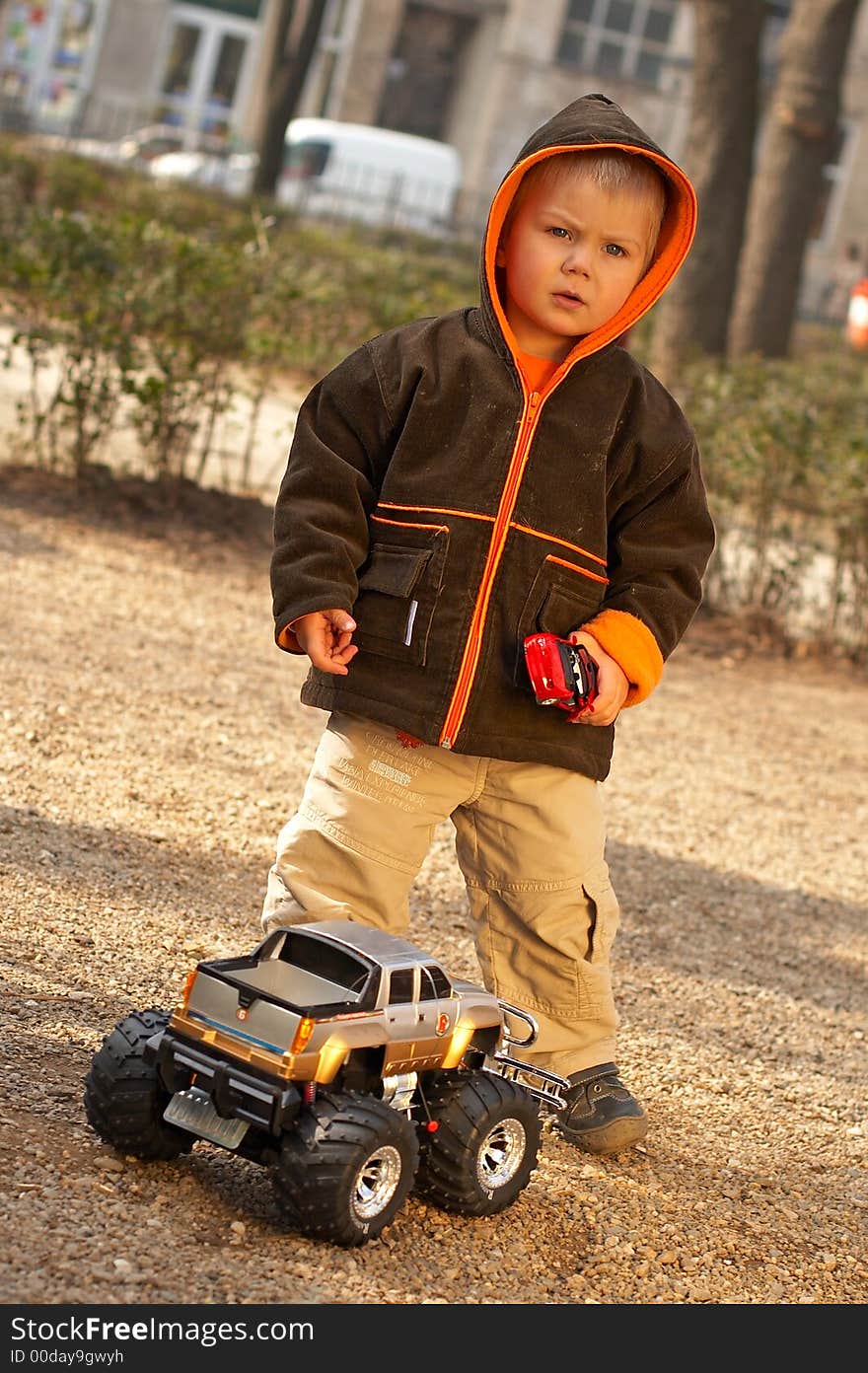 Lovely Baby Boy playing with toy monster truck shot in studio