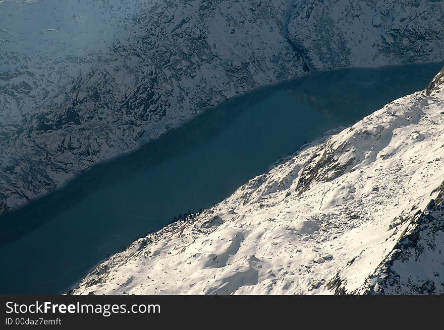 Dark blue lake surrounded by snowy Swiss mountains