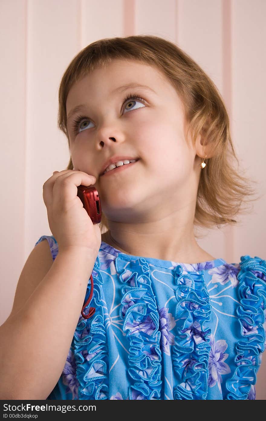 Little girl talking at red mobile phone. Little girl talking at red mobile phone