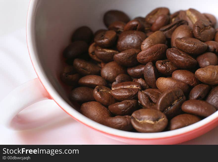 Grains of coffee in a white bowl. Macro-ring