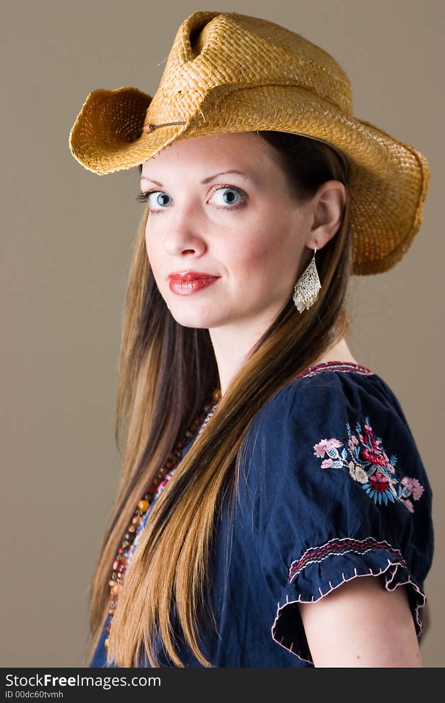 An attractive young brunette woman in a western outfit. An attractive young brunette woman in a western outfit