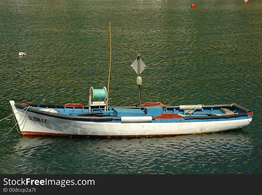 Wood boat floating on the water outside of a an Azores dock. Wood boat floating on the water outside of a an Azores dock