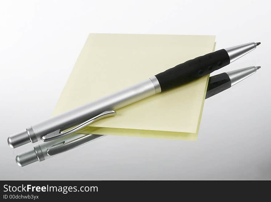 Yellow memo with grey pen. Yellow memo with grey pen