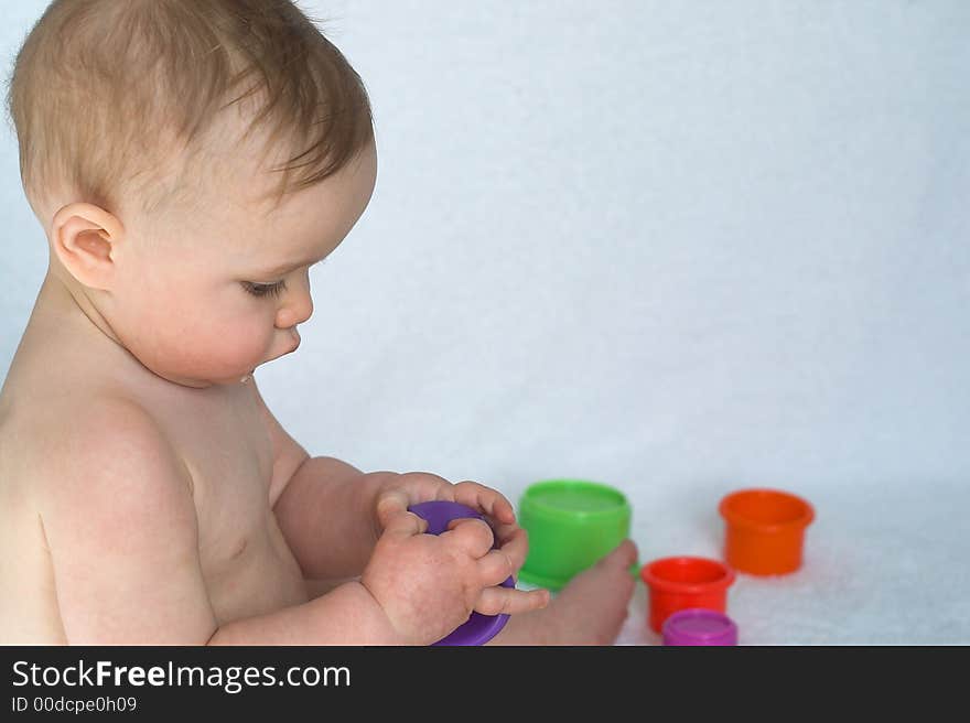 Image of adorable baby playing with stacking cups. Image of adorable baby playing with stacking cups