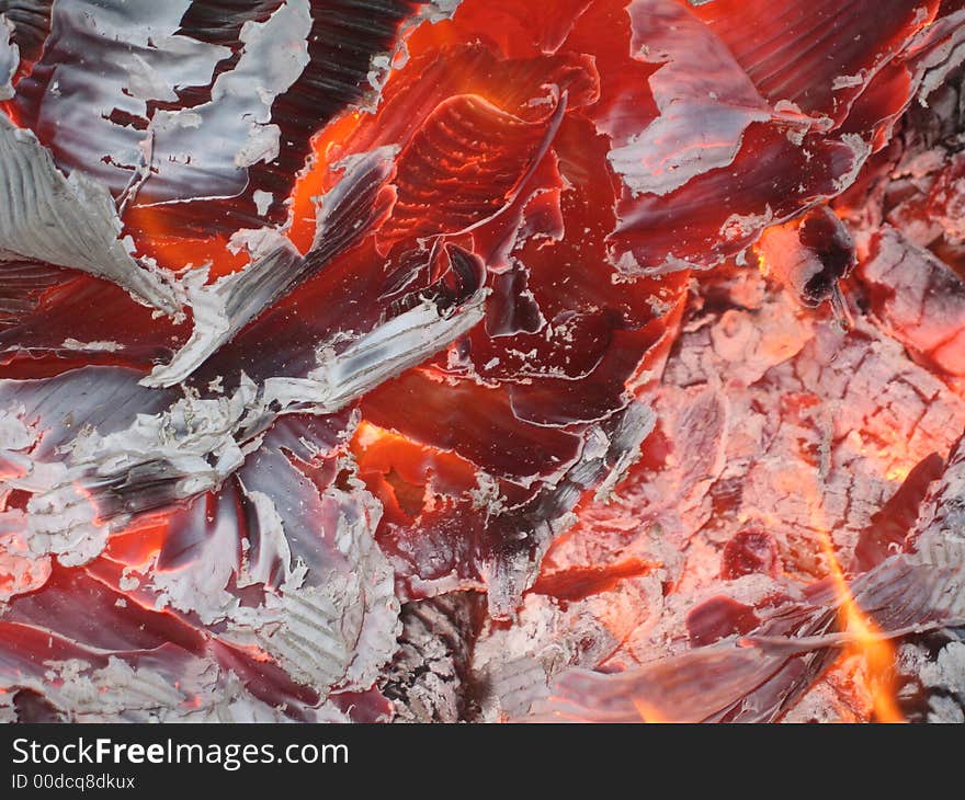 Image of burning ashes after a fire is dying down.