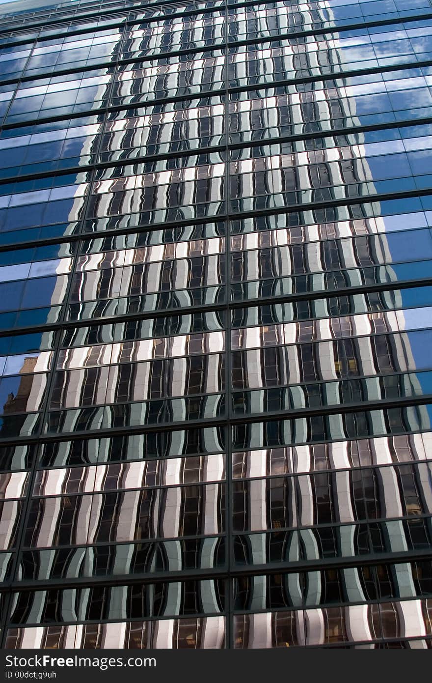 Blue sky reflected in a glass office building. Blue sky reflected in a glass office building