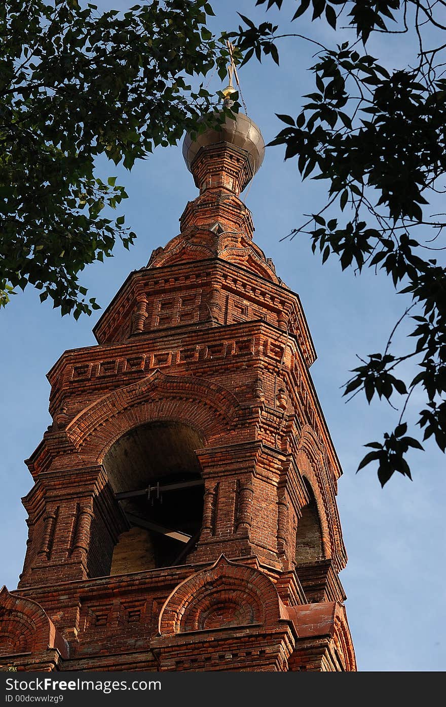 Orthodox brick church between tree leaves. Orthodox brick church between tree leaves