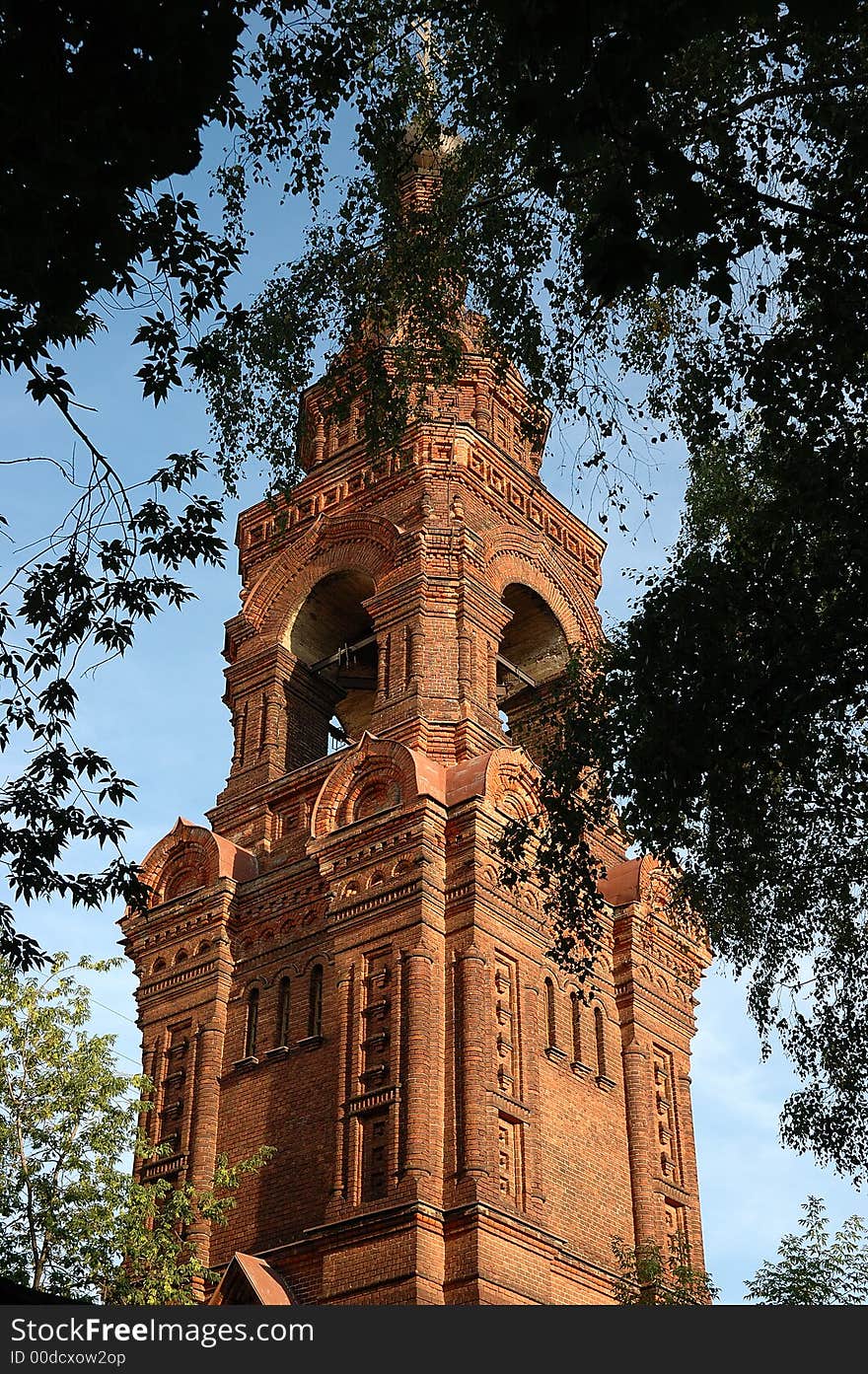 Orthodox brick church between tree leaves. Orthodox brick church between tree leaves