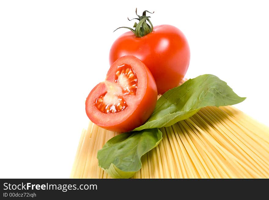 Spaghetti and some of the main ingredients like tomatoes and basil for a delicious pasta meal. Spaghetti and some of the main ingredients like tomatoes and basil for a delicious pasta meal