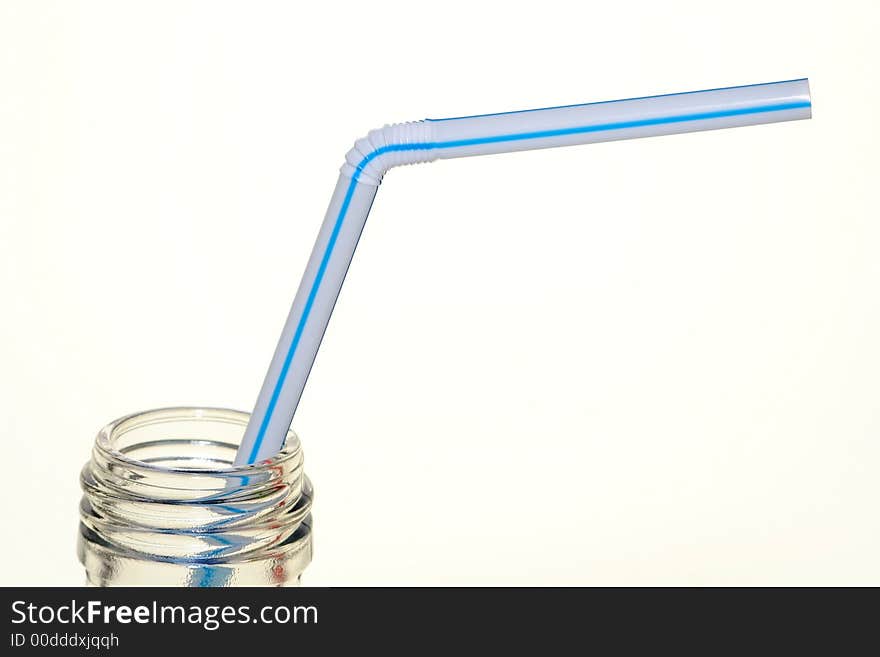 Isolated clear soda bottle and blue striped straw. Isolated clear soda bottle and blue striped straw.