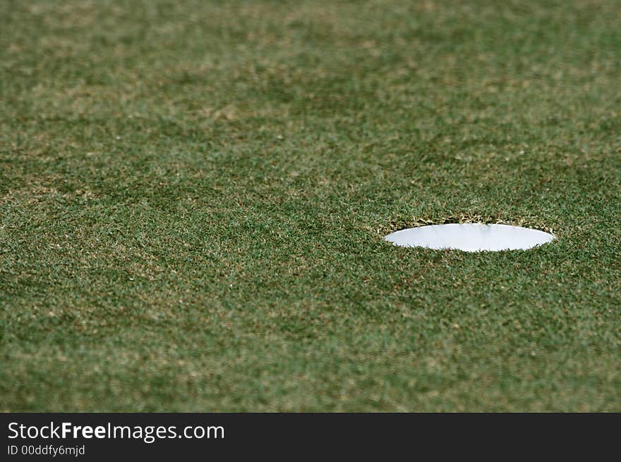 A close up of hole in the golf field.