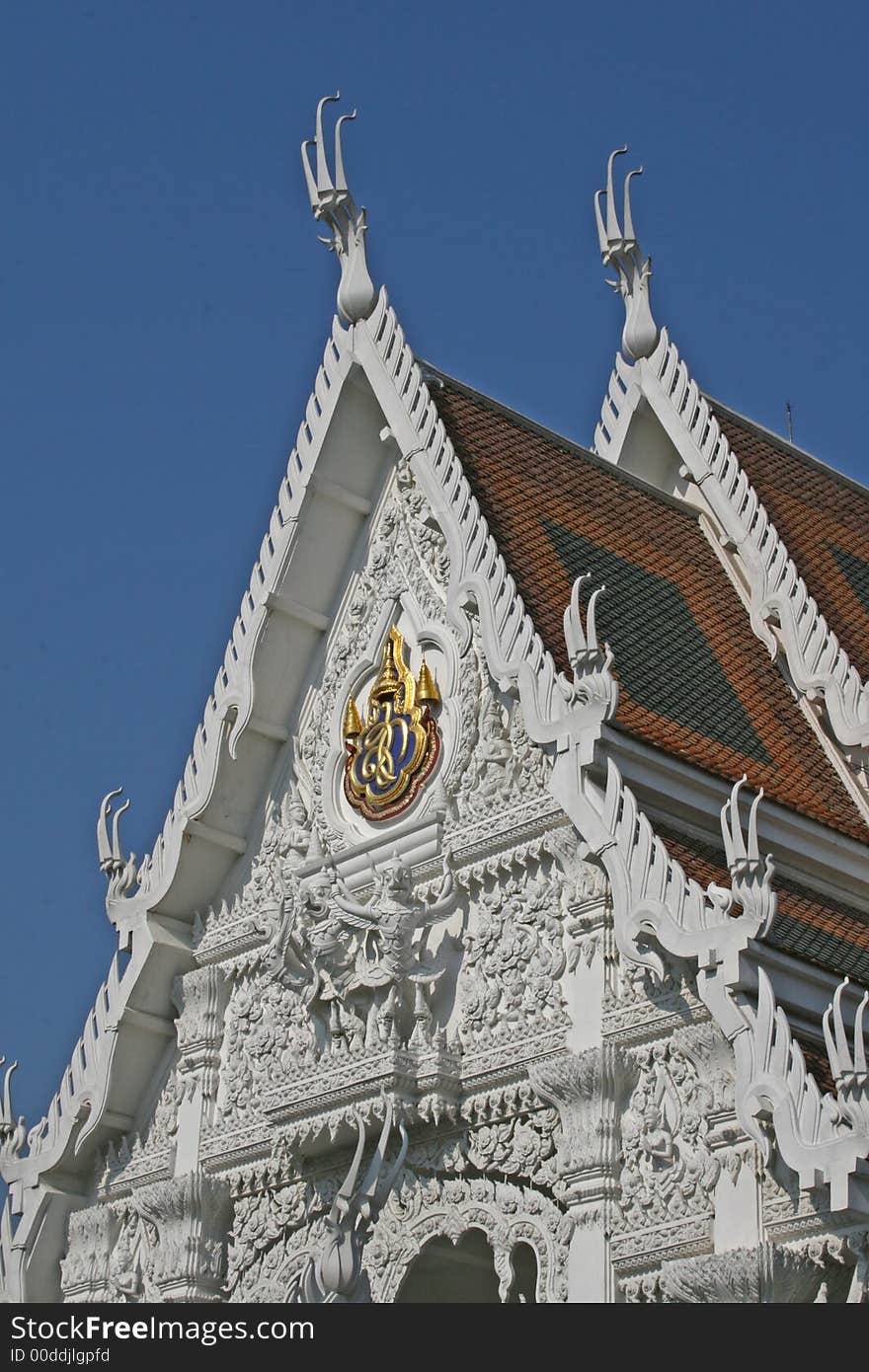 A white Buddhist temple against a deep blue sky background. A white Buddhist temple against a deep blue sky background