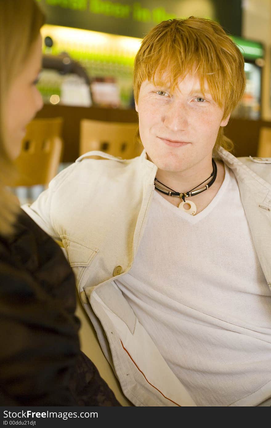 Man's sitting at Cafe. There's a woman next to him. Short depth of focus on man's face. Man's sitting at Cafe. There's a woman next to him. Short depth of focus on man's face.