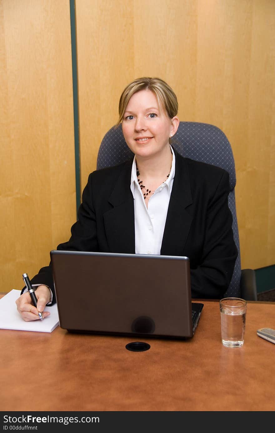 Businesswoman in a board room with his grey laptop. Businesswoman in a board room with his grey laptop