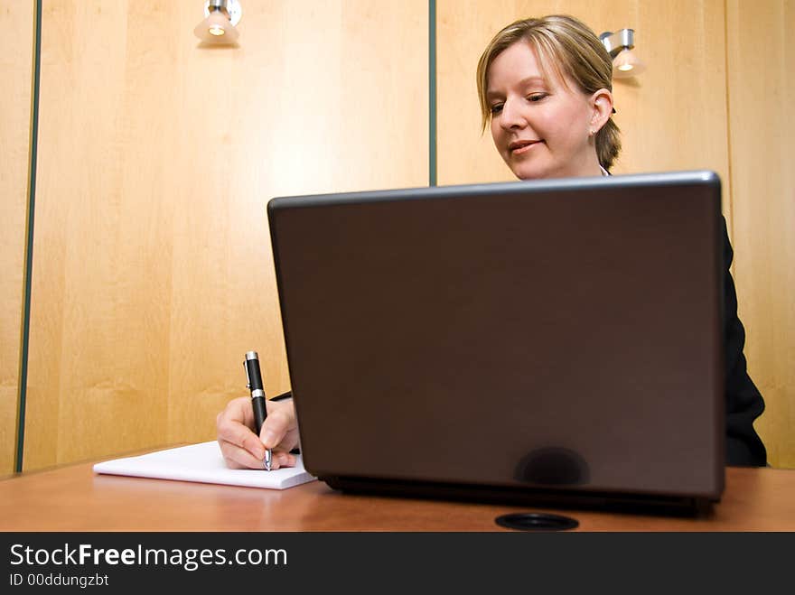 Businesswoman in a board room with his grey laptop. Businesswoman in a board room with his grey laptop