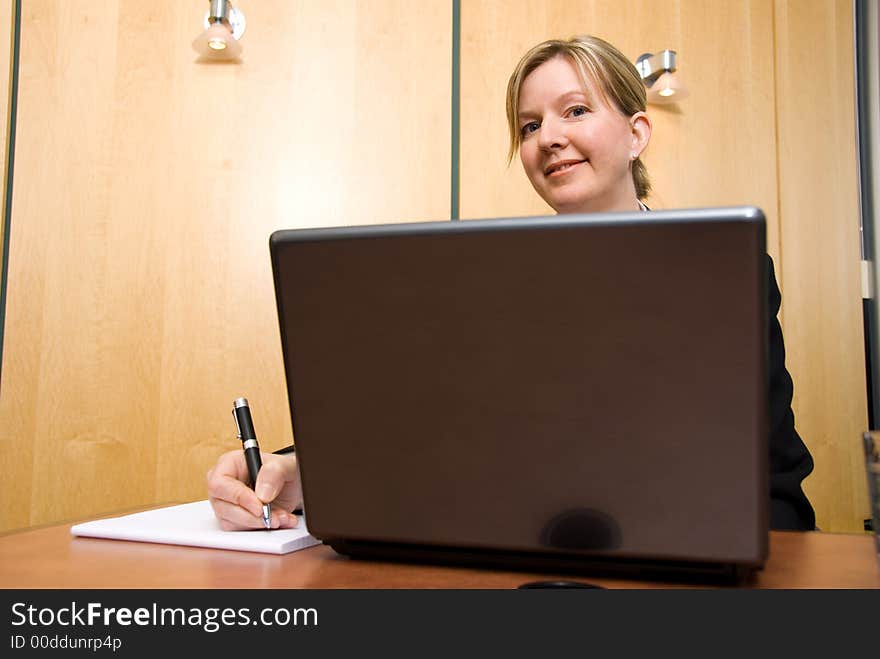 Businesswoman in a board room with his grey laptop. Businesswoman in a board room with his grey laptop