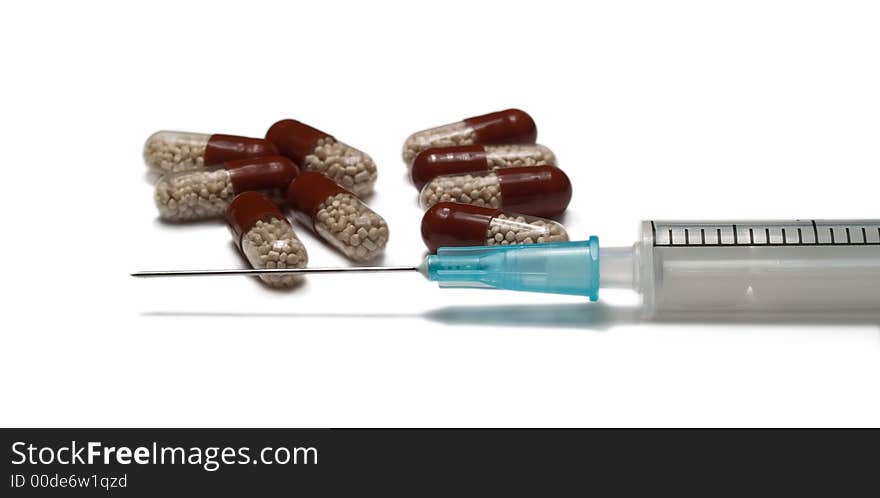 Close-up of syringe and tablets isolated on white. Close-up of syringe and tablets isolated on white