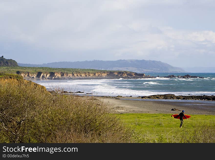 Shot of a central Claifornia beach with a sufer entering the water.