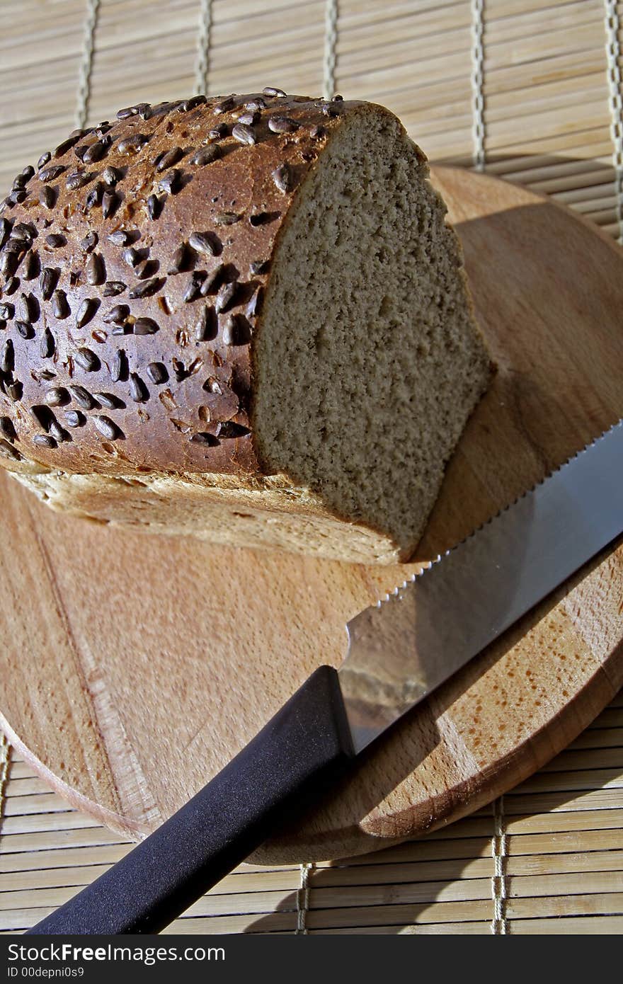 Whole grain bread on a wooden cutting board: healthy nutrition concept