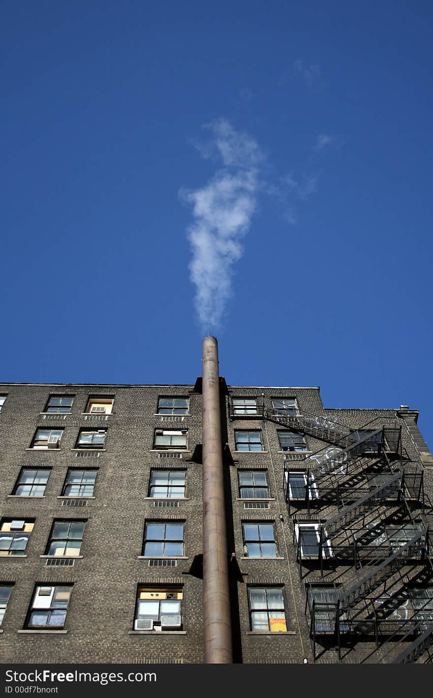 Smoking house. Smoke going out of the chimney of a brick house.