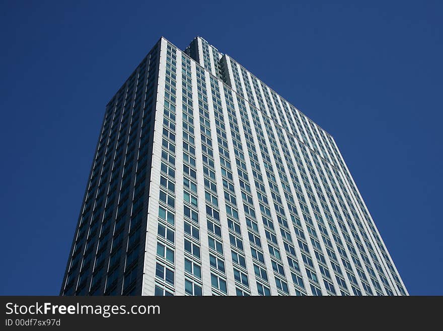 Top of the gray office building against the blue sky.